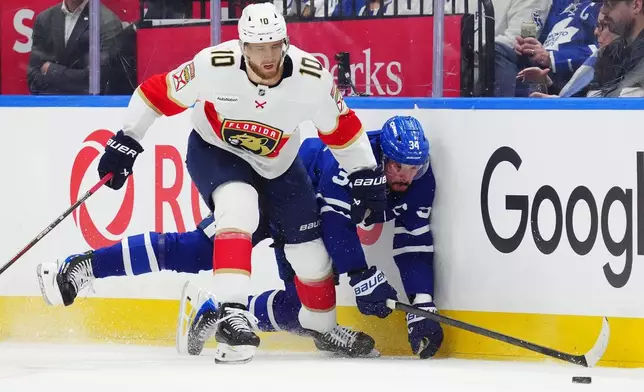 Florida Panthers' A.J. Greer (10) checks Toronto Maple Leafs' Auston Matthews (34) during first period NHL hockey action in Toronto on Tuesday, Jan. 6, 2026. (Frank Gunn/The Canadian Press via AP)