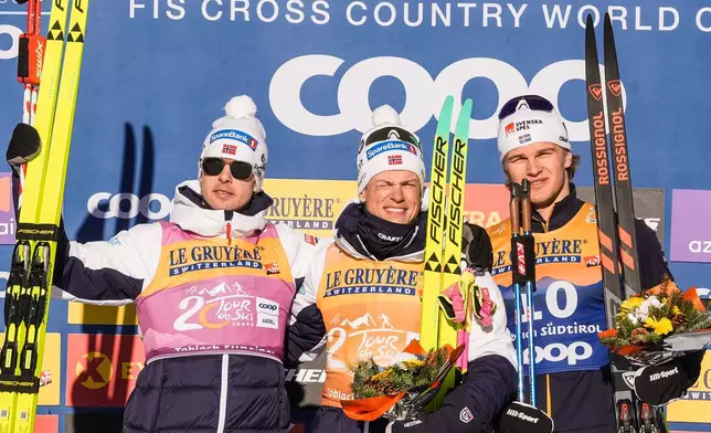 Norway's Johannes Høsflot Klæbo, center, winner of the men's 20 km pursuit classic, part of the Tour de ski, cross-country skiing event, is flanked by second placed Mattis Stenshagen, left, and third placed Sweden's Edvin Anger in Dobbiaco, Italy, Thursday, Jan. 1, 2026. (Terje Pedersen/NTB Scanpix via AP)