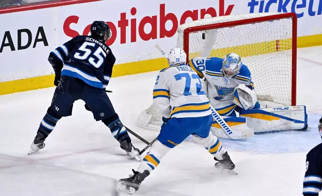 Winnipeg Jets' Mark Scheifele (55) scores on St. Louis Blues' goaltender Joel Hofer (30) during the first period of an NHL hockey game in Winnipeg, Tuesday Jan. 20, 2026. (Fred Greenslade/The Canadian Press via AP)
