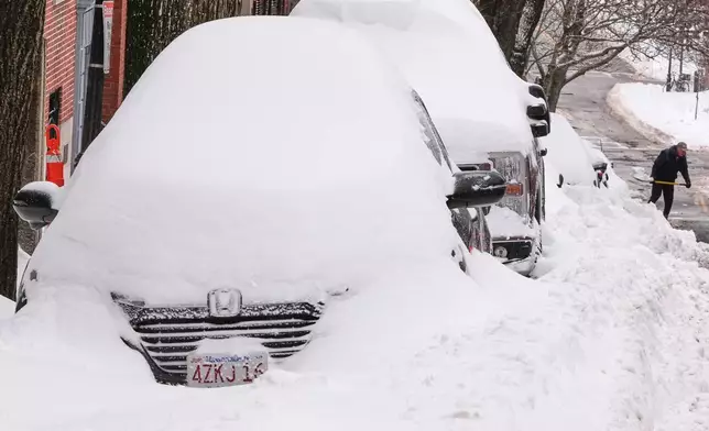 A man digs a car out of the snow on Beacon Hill following a winter storm that dumped more than a foot of snow across the region, Monday, Jan. 26, 2026, in Boston. (AP Photo/Charles Krupa)
