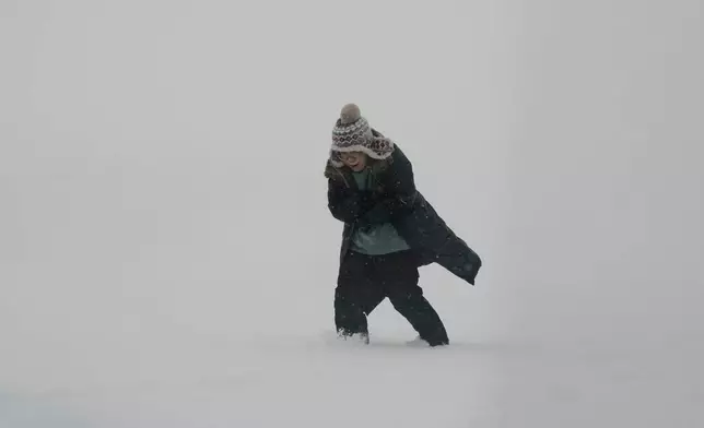 A person bundles up while walking along the shore of Lake Michigan at Montrose beach in Chicago, Sunday, Jan. 25, 2026. (AP Photo/Nam Y. Huh)