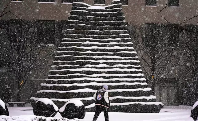 A person walks past snowy stairs in downtown Pittsburgh, Sunday, Jan. 25, 2026. (AP Photo/Gene J. Puskar)