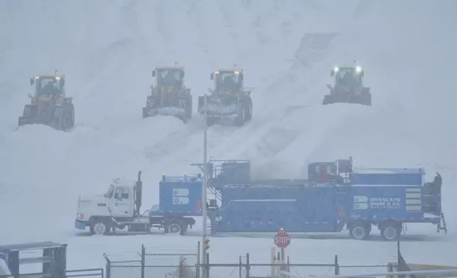 Airport crew plow snow during a winter storm in Philadelphia, Sunday, Jan. 25, 2026. (AP Photo/Matt Rourke)