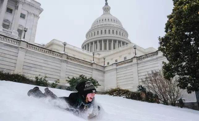 Emilia O'Brien, of Michigan, sleds outside the U.S. Capitol, Sunday, Jan. 25, 2026, in Washington. (AP Photo/Julia Demaree Nikhinson)