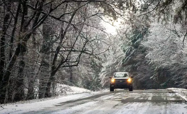 A vehicle travels along an icy portion of the Natchez Trace Parkway Monday, Jan. 26, 2026, in Florence, Ala., as freezing conditions linger after the weekend ice storm. (Dan Busey/The TimesDaily via AP)