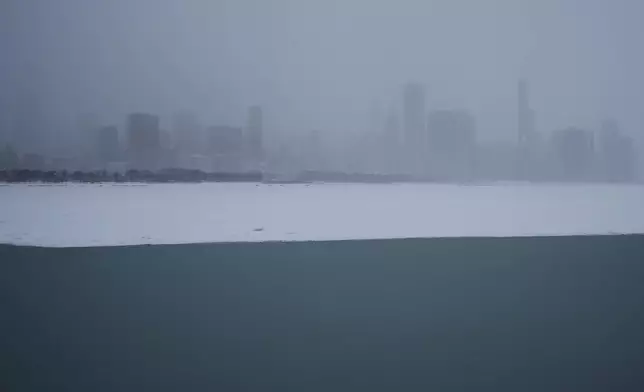 Lake Michigan is covered with snow with the skyline in the background in Chicago, Sunday, Jan. 25, 2026. (AP Photo/Nam Y. Huh)