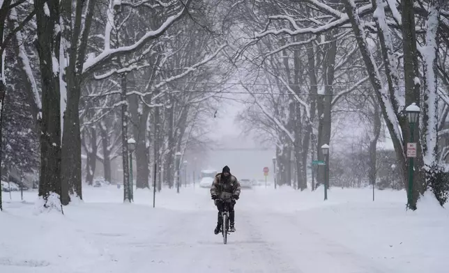 A person rides a bicycle during a snowy day in Evanston, Ill., Sunday, Jan. 25, 2026. (AP Photo/Nam Y. Huh)
