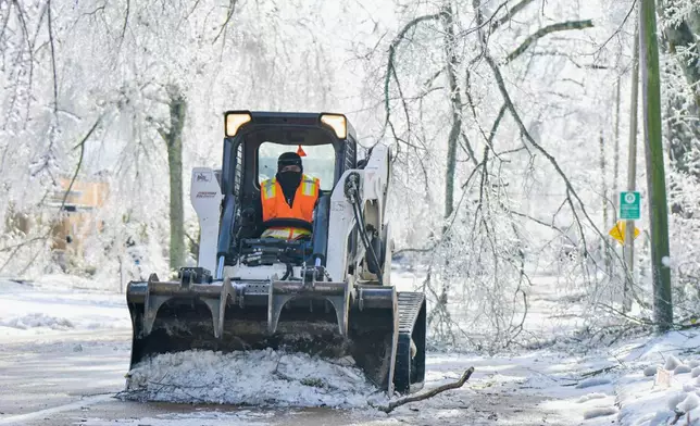 A worker clears a street of debris and ice in Oxford, Miss. on Monday, Jan. 26, 2026, following a weekend ice storm. (AP Photo/Bruce Newman)
