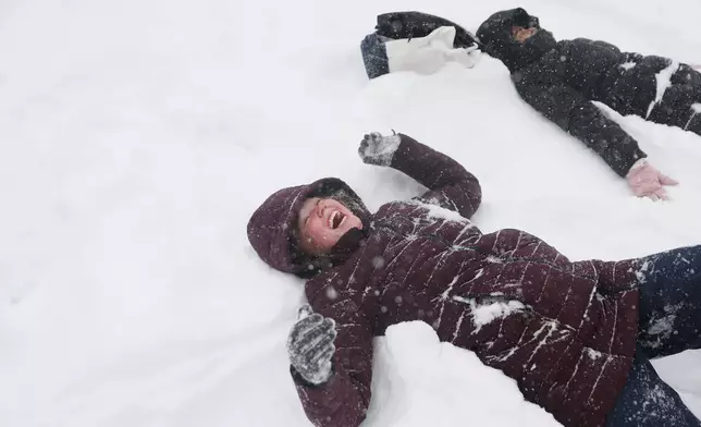 Sadie Eidson, left, laughs while playing in the snow in Central Park during a winter storm, Sunday, Jan. 25, 2026, in New York. (AP Photo/Heather Khalifa)