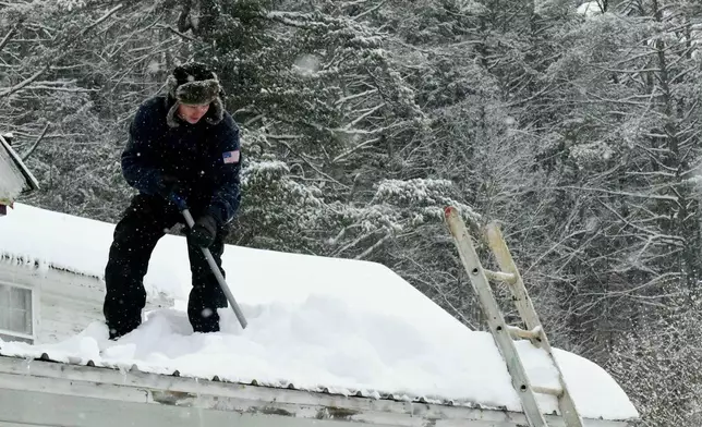Jack Grimes shovels snow off his roof before it could do damage to the building on Monday, Jan. 26, 2026, in Wardsboro, Vt., after Winter Storm Fern dropped several inches of snow. (Kristopher Radder/Brattleboro Reformer via AP)