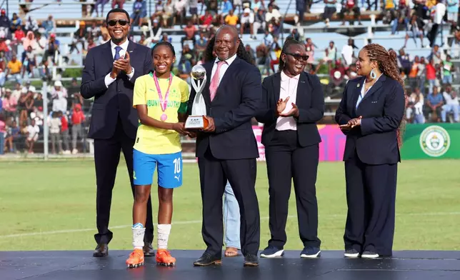 The winning team poses with the trophy after the Under-17 girls tournament promoted by Africa's governing body to promote the cervical cancer vaccination in Norton, Zimbabwe, Thursday, Dec. 18, 2025. (AP Photo/Aaron Ufumeli)