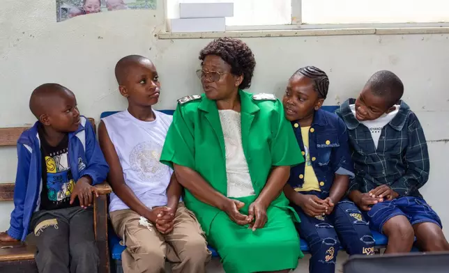 A nurse talks to young girls before they received free doses of the HPV vaccine at Budiriro Polyclinic in Harare, Zimbabwe, Saturday, Jan. 17, 2026. (AP Photo/Aaron Ufumeli)