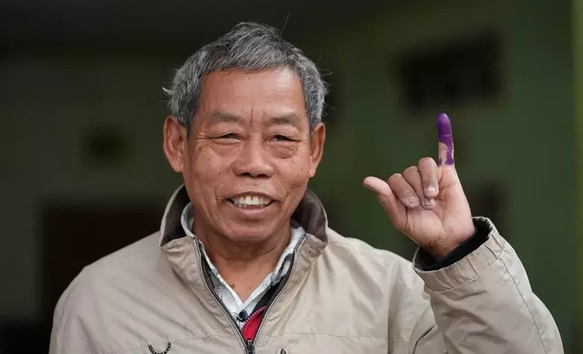 A voter shows his finger, marked with ink to indicate he voted, at a polling station during the second phase of general election in Mandalay, central Myanmar, Sunday, Jan. 11, 2026. (AP Photo/Aung Shine Oo)