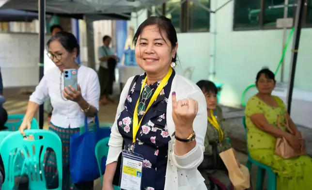 Sandar Min, an individual candidate for an election and former parliament member from ousted leader Aung San Suu Kyi's National League for Democracy (NLD) party, shows off her finger marked with ink indicating she voted at a polling station during the second phase of general election Sunday, Jan. 11, 2026, in Yangon, Myanmar. (AP Photo/Thein Zaw)
