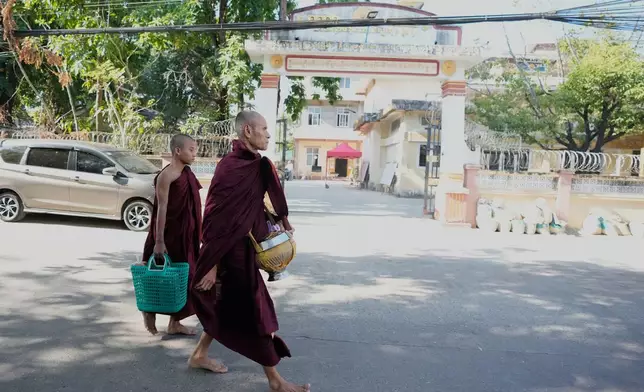 Buddhist monks walk past a polling station opened at a monastery one day before the second phase of the general election in Yangon, Myanmar, Saturday, Jan. 10, 2026. (AP Photo/Thein Zaw)