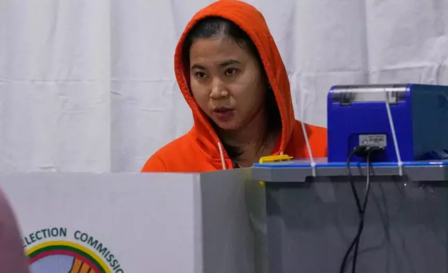 A voter casts ballot at a polling station during the second phase of general election in Mandalay, central Myanmar, Sunday, Jan. 11, 2026. (AP Photo/Aung Shine Oo)