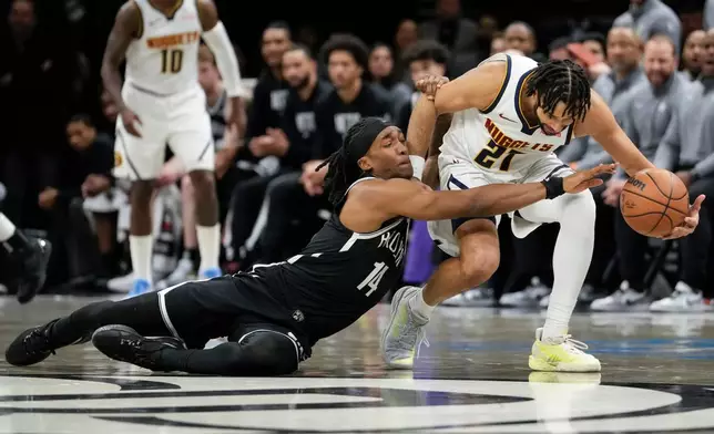 Brooklyn Nets guard Terance Mann (14) fights for control of the ball with Denver Nuggets guard Jamal Murray (27) during the first half of an NBA basketball game, Sunday, Jan. 4, 2026, in New York. (AP Photo/Yuki Iwamura)