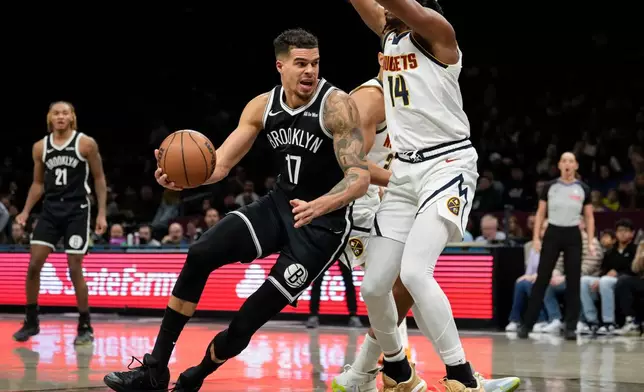 Brooklyn Nets forward Michael Porter Jr. (17) falls as he attempts to shoot during the first half of an NBA basketball game against the Denver Nuggets, Sunday, Jan. 4, 2026, in New York. (AP Photo/Yuki Iwamura)