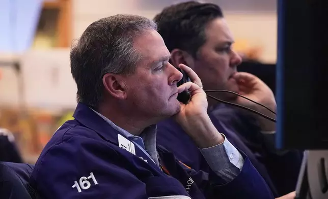 Trader Thomas McCauley, foreground, and a colleague work on the floor of the New York Stock Exchange, Friday, Jan. 2, 2026. (AP Photo/Richard Drew)