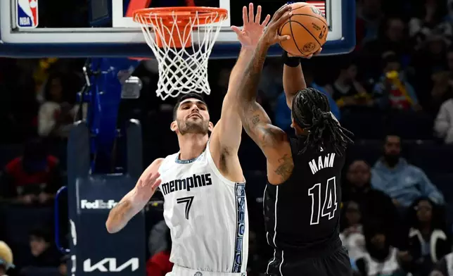 Memphis Grizzlies forward Santi Aldama (7) defends Brooklyn Nets guard Terance Mann (14) in the first half of an NBA basketball game, Sunday, Jan. 11, 2026, in Memphis, Tenn. (AP Photo/Brandon Dill)