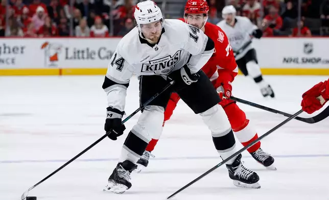 Los Angeles Kings right wing Alex Laferriere (14) goes past Detroit Red Wings center Dylan Larkin (71) to take a shot on goal during the second period of an NHL hockey game Tuesday, Jan. 27, 2026, in Detroit. (AP Photo/Duane Burleson)