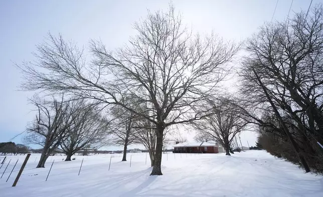 Ice and snow cover the exterior of a residence near a pond where neighbors say three young boys died after falling into the water, Tuesday, Jan. 27, 2026, in Bonham, Texas. (AP Photo/Julio Cortez)