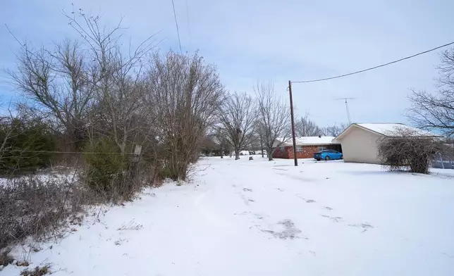Ice and snow cover the exterior of a residence near a pond where neighbors say three young boys died after falling into the water, Tuesday, Jan. 27, 2026, in Bonham, Texas. (AP Photo/Julio Cortez)