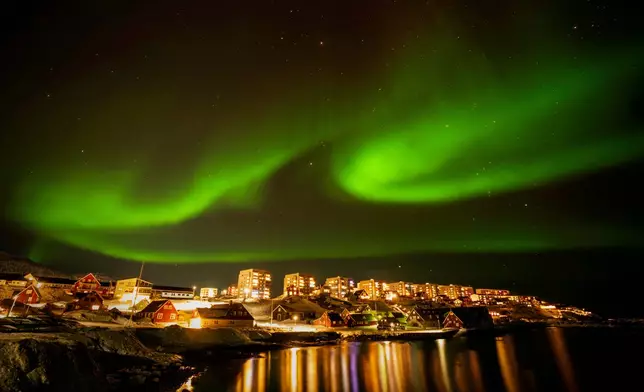 FILE - The northern lights appear over homes in Nuuk, Greenland, on Feb. 17, 2025. (AP Photo/Emilio Morenatti, File)