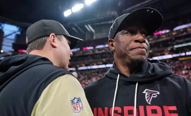 Atlanta Falcons head coach Raheem Morris, right, greets New Orleans Saints head coach Kellen Moore after an NFL football game, Sunday, Jan. 4, 2026, in Atlanta. (AP Photo/Brynn Anderson)