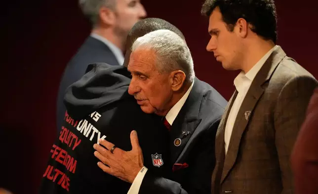 Atlanta Falcons owner Arthur Blank, right, hugs head coach Raheem Morris after an NFL football game against the New Orleans Saints, Sunday, Jan. 4, 2026, in Atlanta. (AP Photo/Mike Stewart)