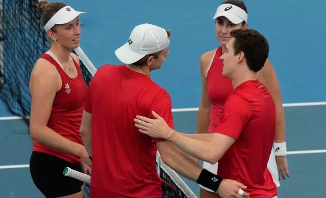 Belinda Bencic, second right, and Jakub Paul, right, of Switzerland shake hands with Alise Mertens, left, and Zizou Bergs of Belgium after Switzerland won their semifinal doubles match at the United Cup tennis tournament in Sydney, Saturday, Jan. 10, 2026. (AP Photo/Rick Rycroft)
