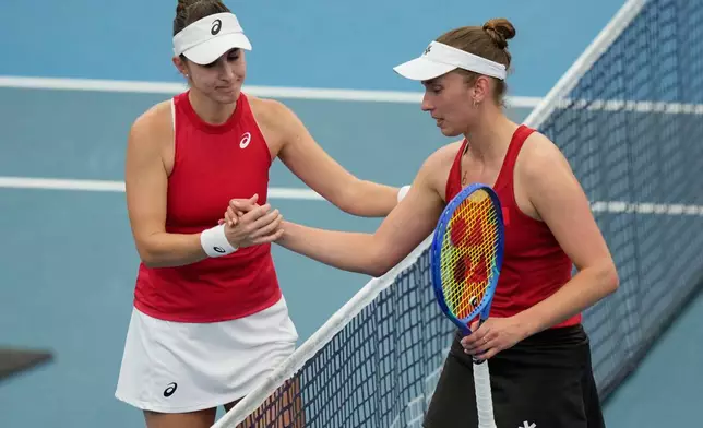 Belinda Bencic of Switzerland, left and Alise Mertens of Belgium meet at the net after Bencic won their semifinal match at the United Cup tennis tournament in Sydney, Saturday, Jan. 10, 2026. (AP Photo/Rick Rycroft)