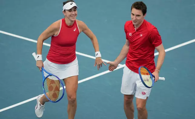 Belinda Bencic, left, and Jakub Paul of Switzerland celebrate winning a point against Alise Mertens and Zizou Bergs of Belgium during their semifinal doubles match at the United Cup tennis tournament in Sydney, Saturday, Jan. 10, 2026. (AP Photo/Rick Rycroft)
