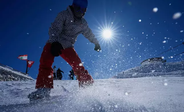 A snowboarder rides down a slope at the Mzaar-Kfardebian ski resort northeast of Beirut, Lebanon, Saturday, Jan. 3, 2026. (AP Photo/Hassan Ammar)