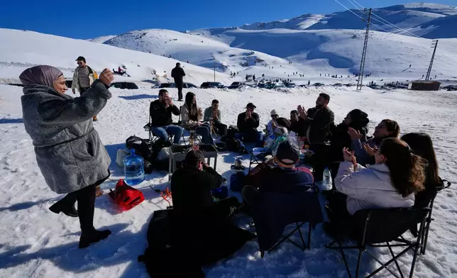 People gather to picnic and socialize in the snow near the Mzaar-Kfardebian ski resort northeast of Beirut, Lebanon, Saturday, Jan. 3, 2026. (AP Photo/Hassan Ammar)
