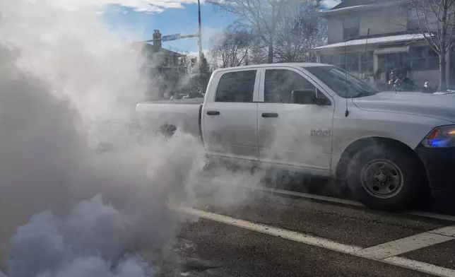 Federal agents drive through smoke from tear gas dispersed during a protest, Monday, Jan. 12, 2026 in Minneapolis (AP Photo/Adam Gray)