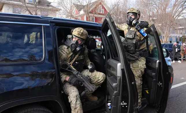 Federal agents get ready to disperse tear gas into a crowd at a protest, Monday, Jan. 12, 2026 in Minneapolis (AP Photo/Adam Gray)