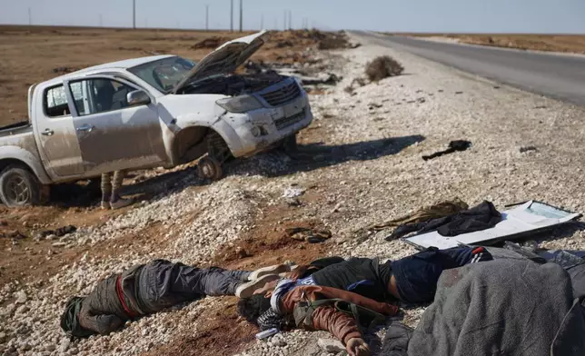 FILE - The bodies of retreating Syrian Democratic Forces fighters lie on the side of the road between government-controlled Raqqa and SDF-controlled Hassakeh, in northeastern Syria, Tuesday, Jan. 20, 2026. (AP Photo/Omar Albam, File)