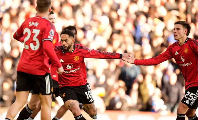 Manchester United's Matheus Cunha, center, celebrates after scoring his sides first goal during the English Premier League soccer match between Leeds United and Manchester United in Leeds, England, Sunday, Jan. 4, 2026. (Danny Lawson/PA via AP)