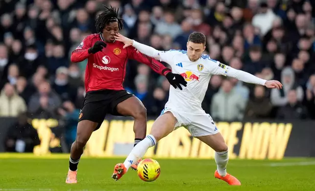 Manchester United's Patrick Dorgu, left, and Leeds United's Gabriel Gudmundsson battle for the ball during the English Premier League soccer match between Leeds United and Manchester United in Leeds, England, Sunday, Jan. 4, 2026. (Danny Lawson/PA via AP)