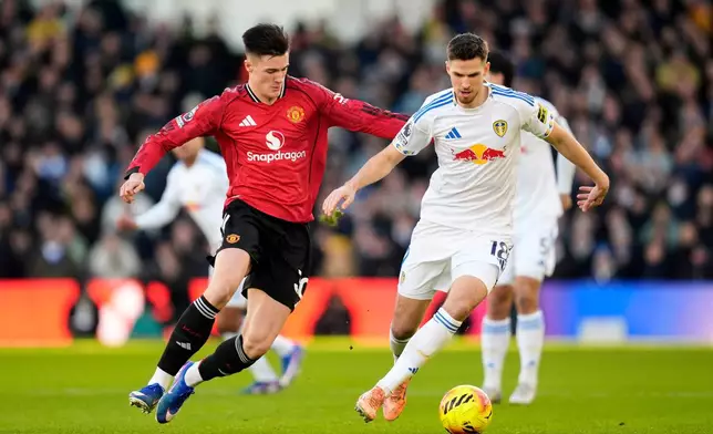 Manchester United's Benjamin Sesko, left, and Leeds United's Anton Stach battle for the ball during the English Premier League soccer match between Leeds United and Manchester United in Leeds, England, Sunday, Jan. 4, 2026. (Danny Lawson/PA via AP)