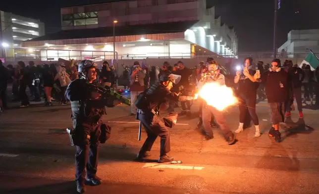 Los Angeles police fire less lethal rounds at protesters in downtown Los Angeles on Friday, Jan. 30, 2026. (AP Photo/Jae C. Hong)