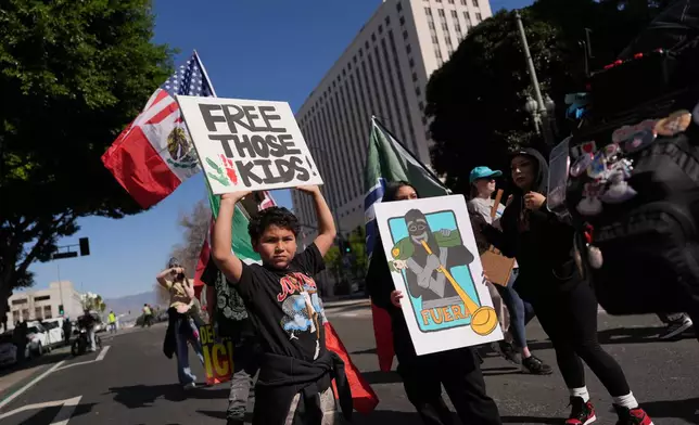 People gather near Los Angels City Hall, during a protest on Friday, Jan. 30, 2026. (AP Photo/Jae C. Hong)