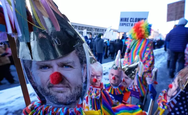 Photos of Vice President JD Vance, left, and other members of the Trump administration dressed as clowns are seen during a protest Friday, Jan. 30, 2026, in Minneapolis. (AP Photo/Alex Brandon)