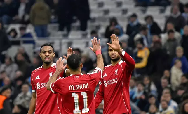 Liverpool's Cody Gakpo, right, celebrates with Liverpool's Mohamed Salah, centre, and Liverpool's Ryan Gravenberch after scoring his side's third goal during the Champions League opening phase soccer match between Marseille and Liverpool in Marseille, France, Wednesday, Jan. 21, 2026. (AP Photo/Philippe Magoni)