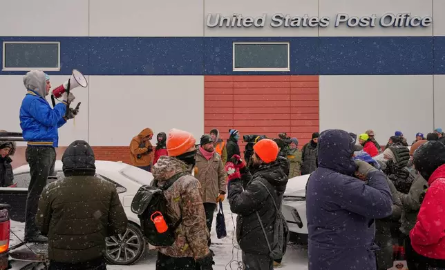 People gather near the post office during a protest, Sunday, Jan. 18, 2026, in Minneapolis. (AP Photo/Yuki Iwamura)