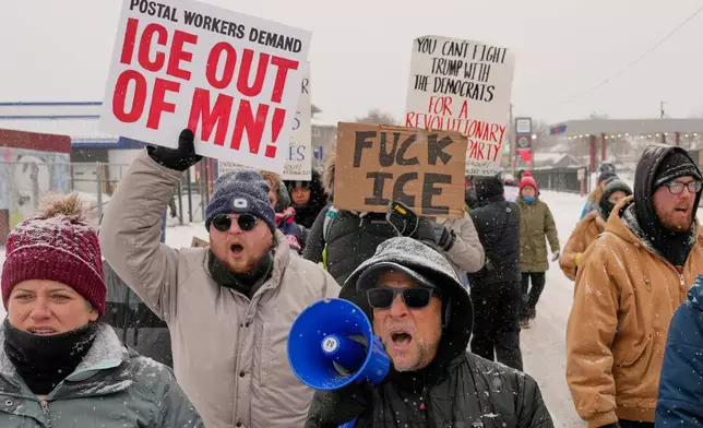 EDS NOTE: OBSCENITY - People march and gather near the post office during a protest, Sunday, Jan. 18, 2026, in Minneapolis. (AP Photo/Yuki Iwamura)