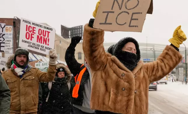 People gather near the post office during a protest, Sunday, Jan. 18, 2026, in Minneapolis. (AP Photo/Yuki Iwamura)