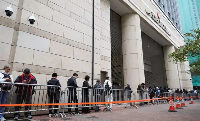 People line up behind the barricades to attend the hearing about the upcoming sentence for pro-democracy media mogul Jimmy Lai, outside the West Kowloon Magistrates' Courts, in Hong Kong, Monday, Jan. 12, 2026. (AP Photo/May James)
