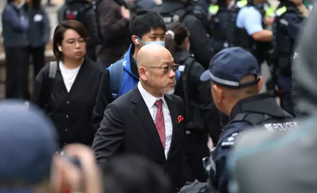Robert Pang, center, lawyer for pro-democracy media mogul Jimmy Lai arrives to the West Kowloon Magistrates' Courts, ahead of a hearing to hear arguments about the sentencing of Lai, in Hong Kong, Monday, Jan. 12, 2026. (AP Photo/May James)